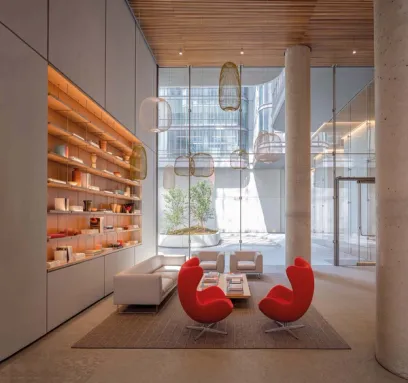 a living room with a couch , chairs , coffee table and shelves .