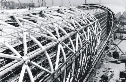 a black and white photo of a large building under construction .