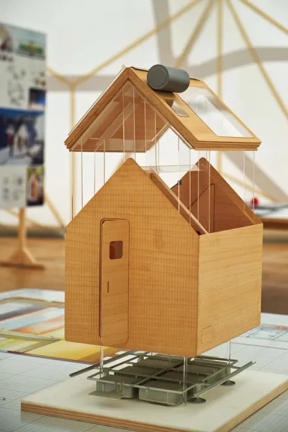 a model of a wooden house with a solar panel on the roof