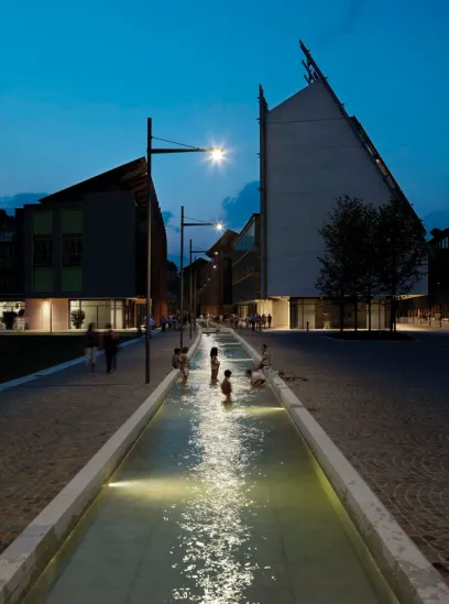 a group of people are playing in a fountain at night
