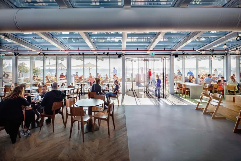 A group of people are sitting at tables in a restaurant