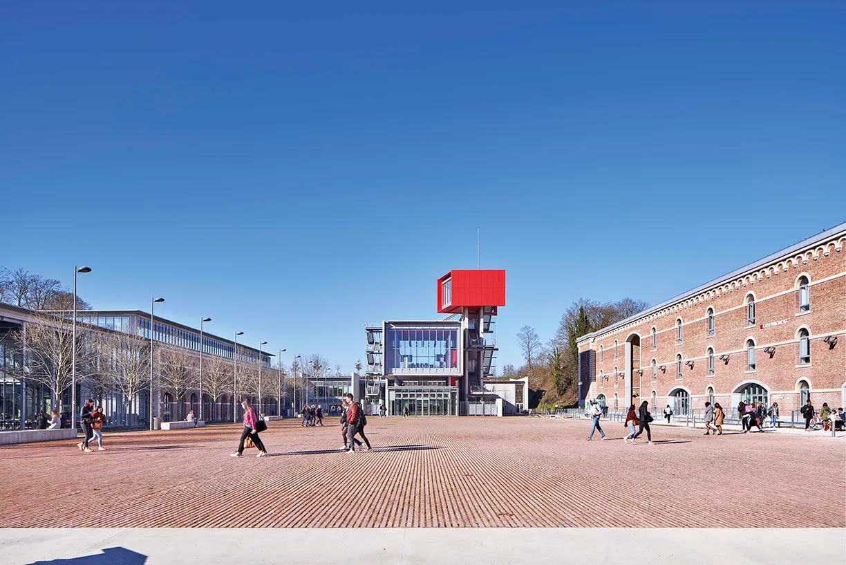 A group of people are walking in a square in front of a large building