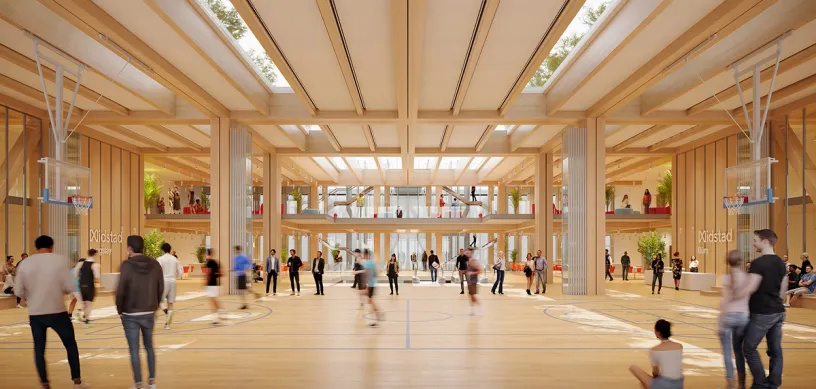 a group of people are standing around a basketball court in a large building .