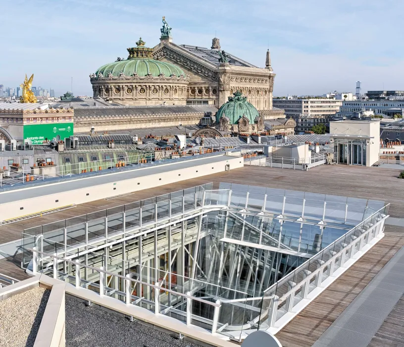 An aerial view of a rooftop with a large building in the background