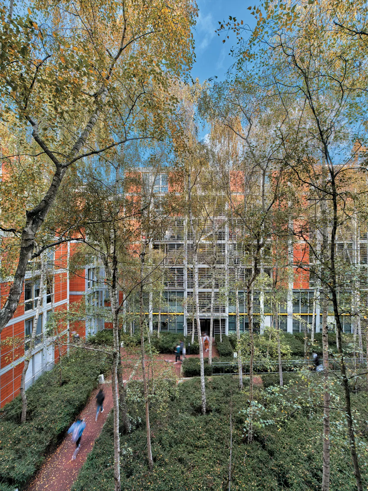 a building with a lot of windows and trees in front of it