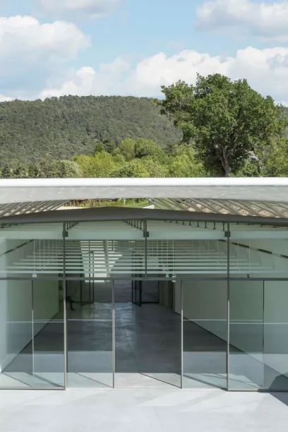 A large glass building with a mountain in the background