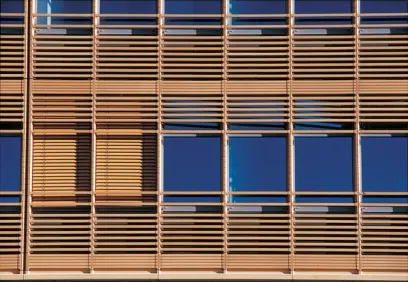A building with a lot of windows and wooden blinds on it