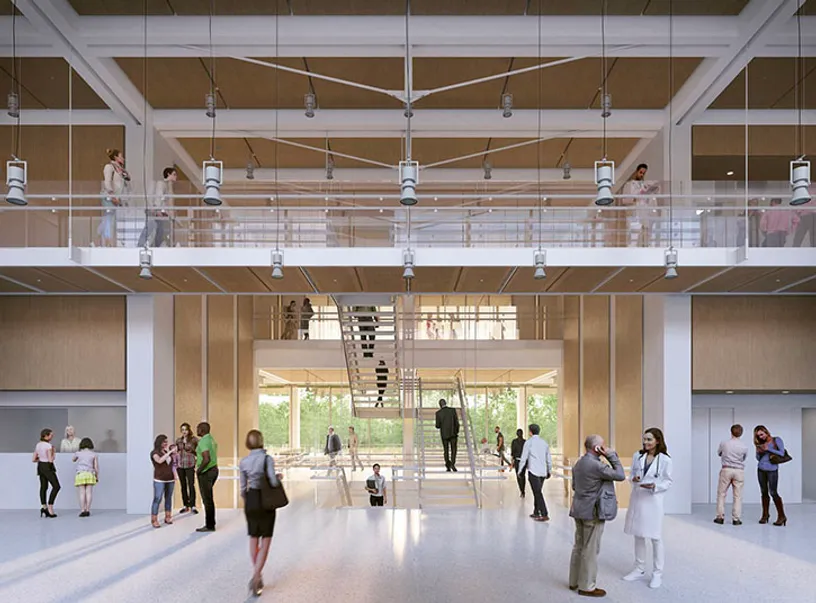 a group of people are standing in a large room with stairs .