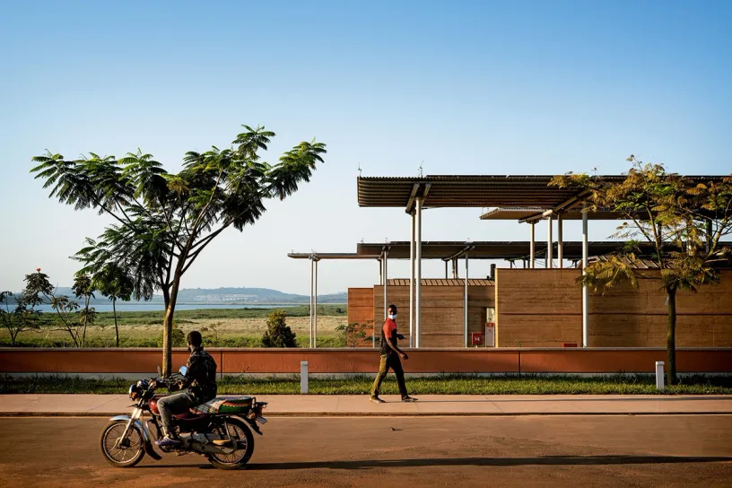 A man is riding a motorcycle down a street next to a building