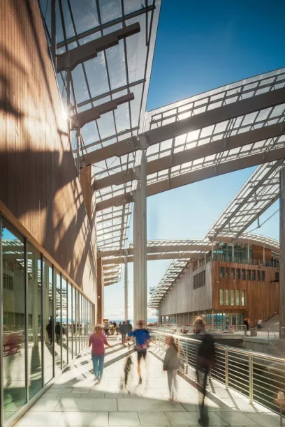 A group of people are walking under a glass roof