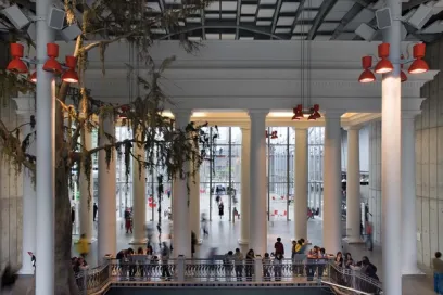 a group of people are standing on a bridge in a building .