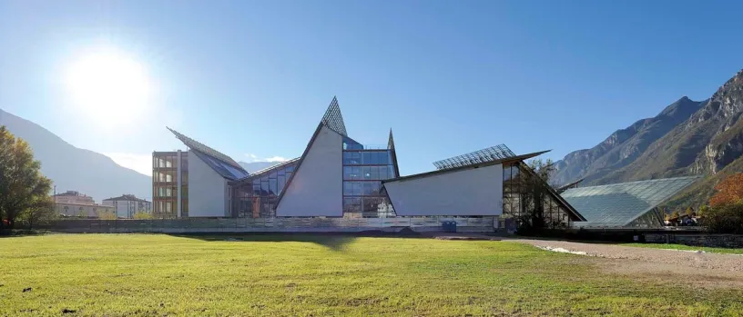 a large building with a lot of windows is sitting in the middle of a grassy field .