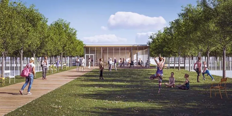 A group of people are sitting on the grass in front of a building