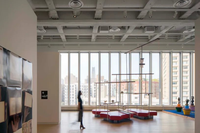a woman is walking through a large room with a lot of windows .