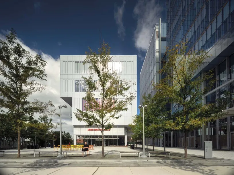a large white building with a lot of windows and trees in front of it .