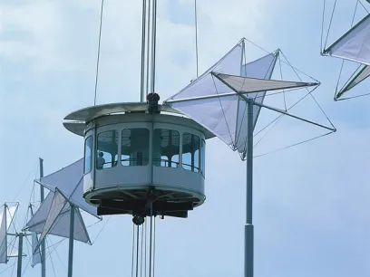 A ferris wheel is being lifted up into the sky by a crane