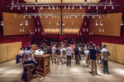 a group of construction workers are working on a large wooden structure in a building .