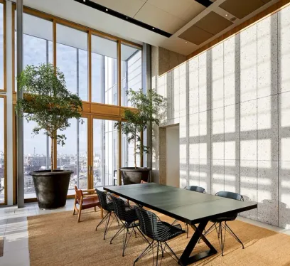 a dining room with a table and chairs and potted plants .