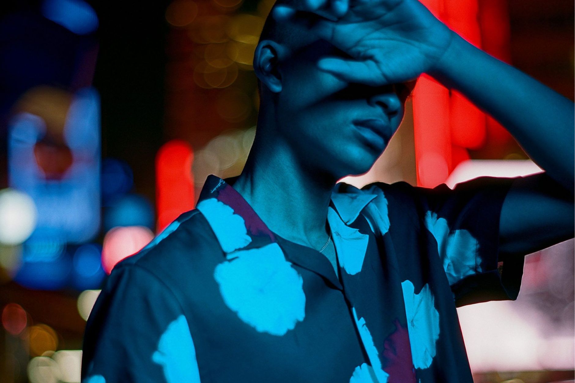 Man shielding his eyes at night wearing Saturdays shirt