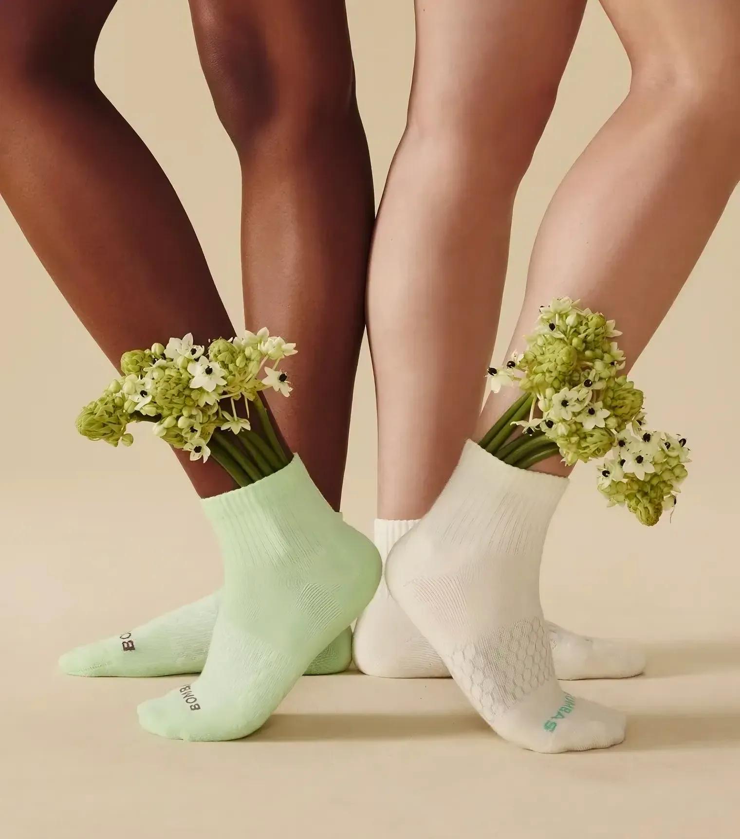 A variety of Bombas socks in different colors sitting on a blue background