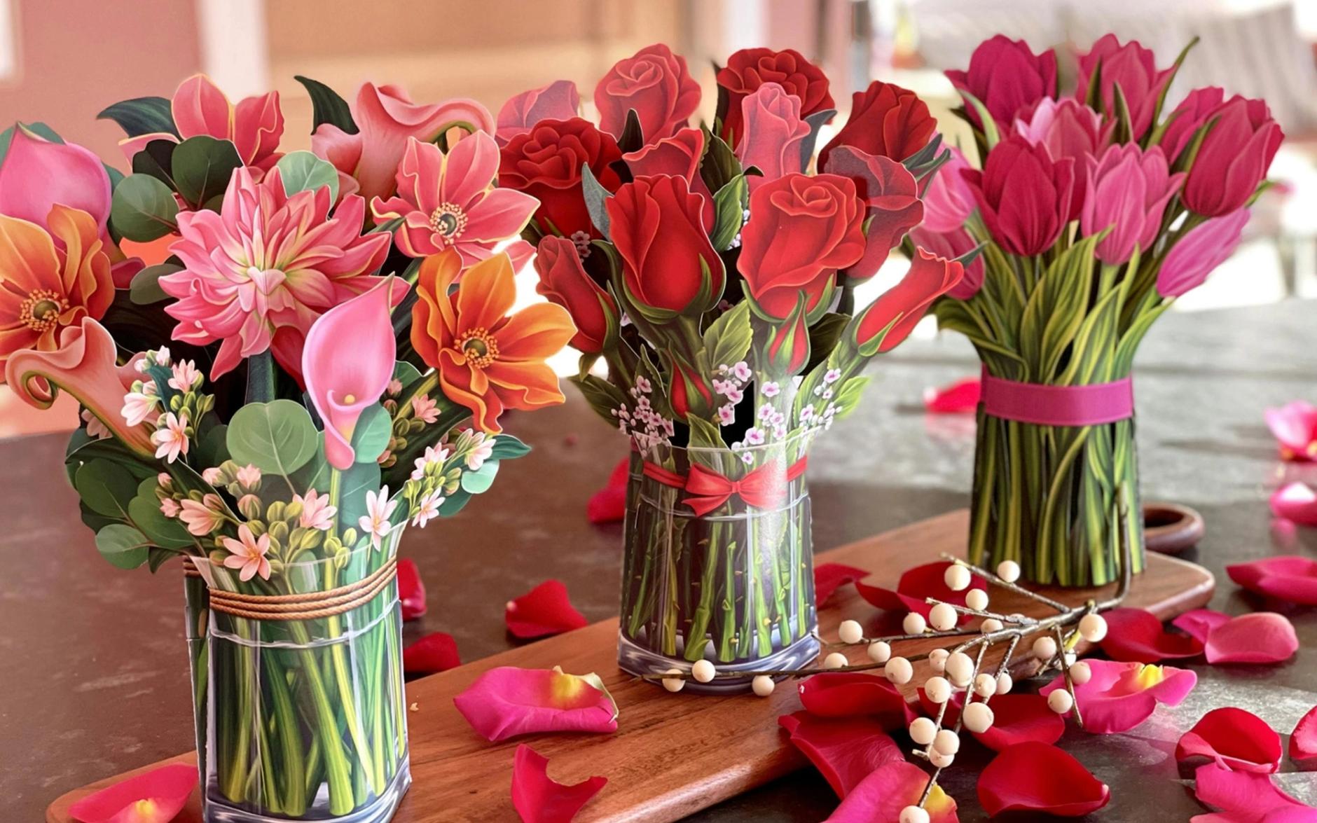 3 paper flower bouquets sitting on a table