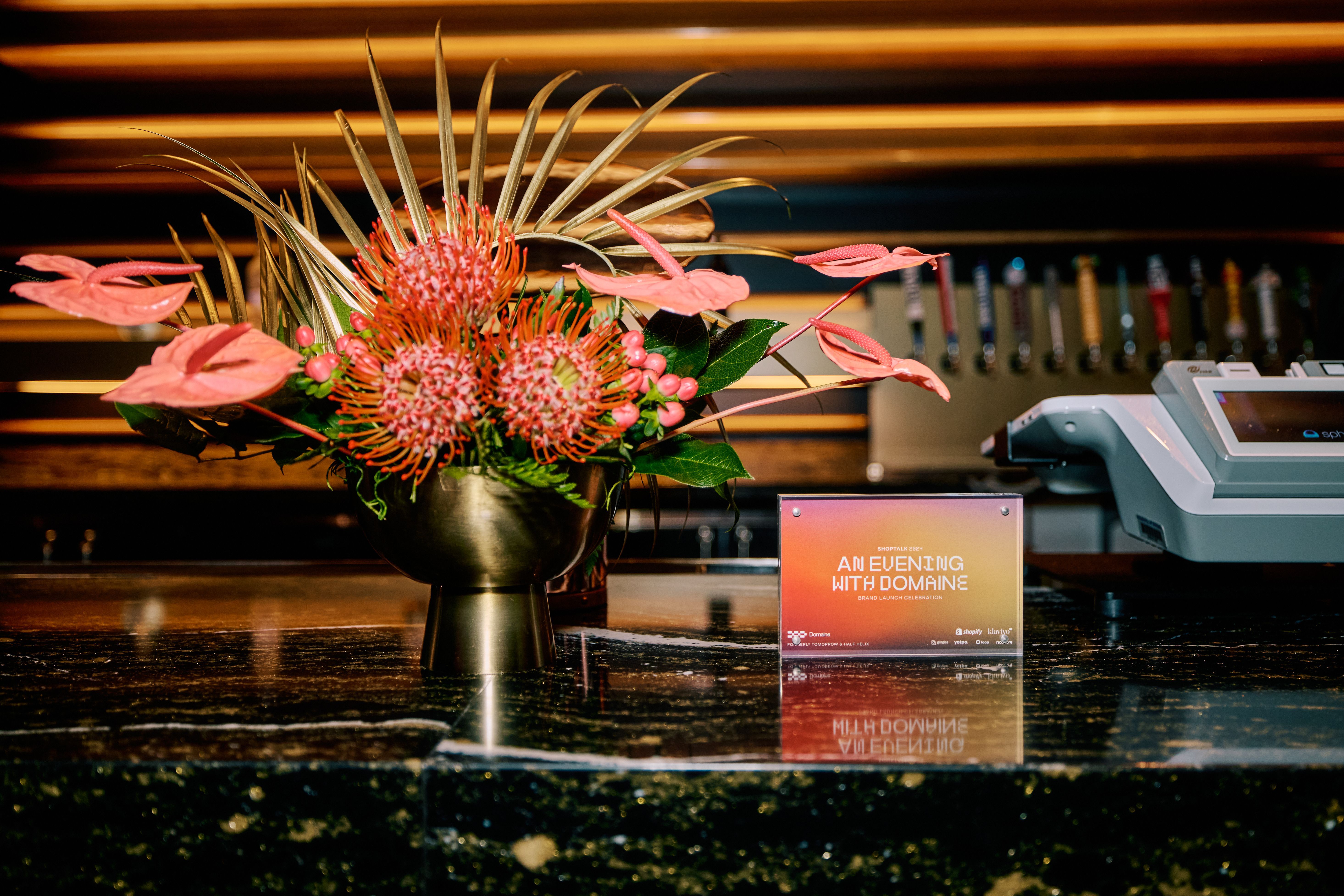 An image of a sign that says 'An Evening with Someone' on the bar with orange florals