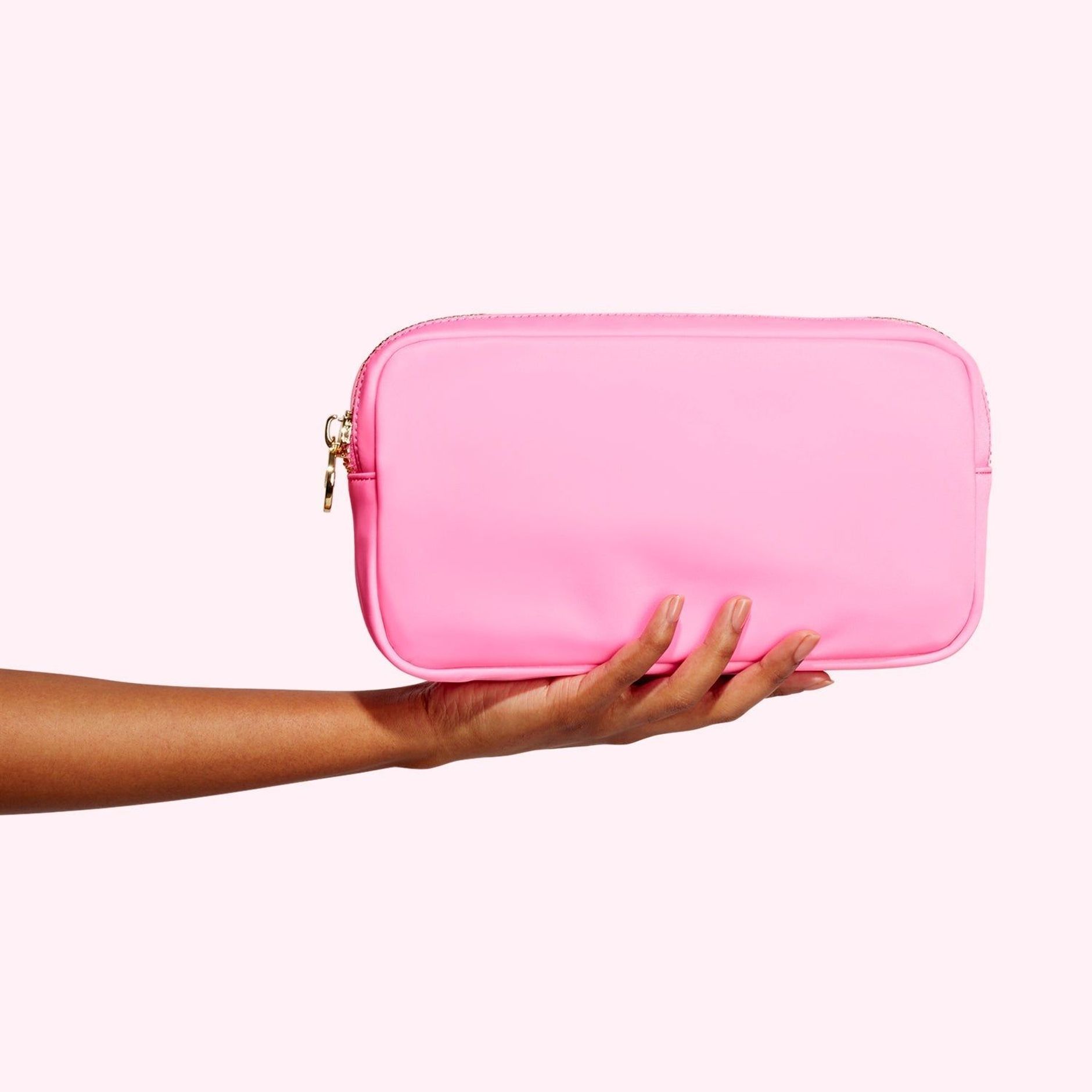 Hand holding a small pink pouch