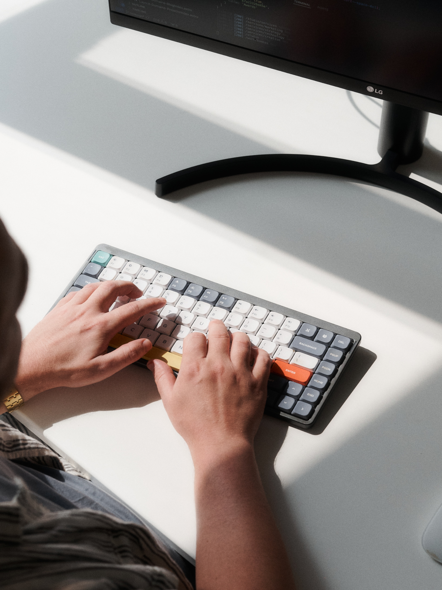 Hands typing on a keyboard in front of a monitor