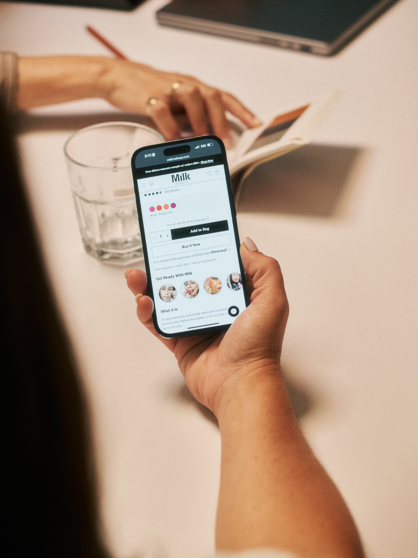 Hand holding phone showing a product page