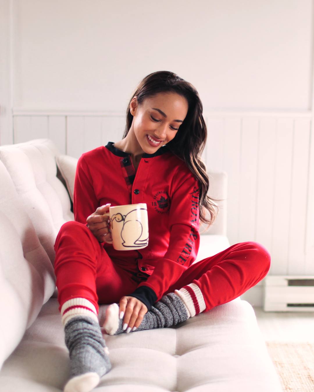 Lady in pyjamas on sofa with a cup of coffee