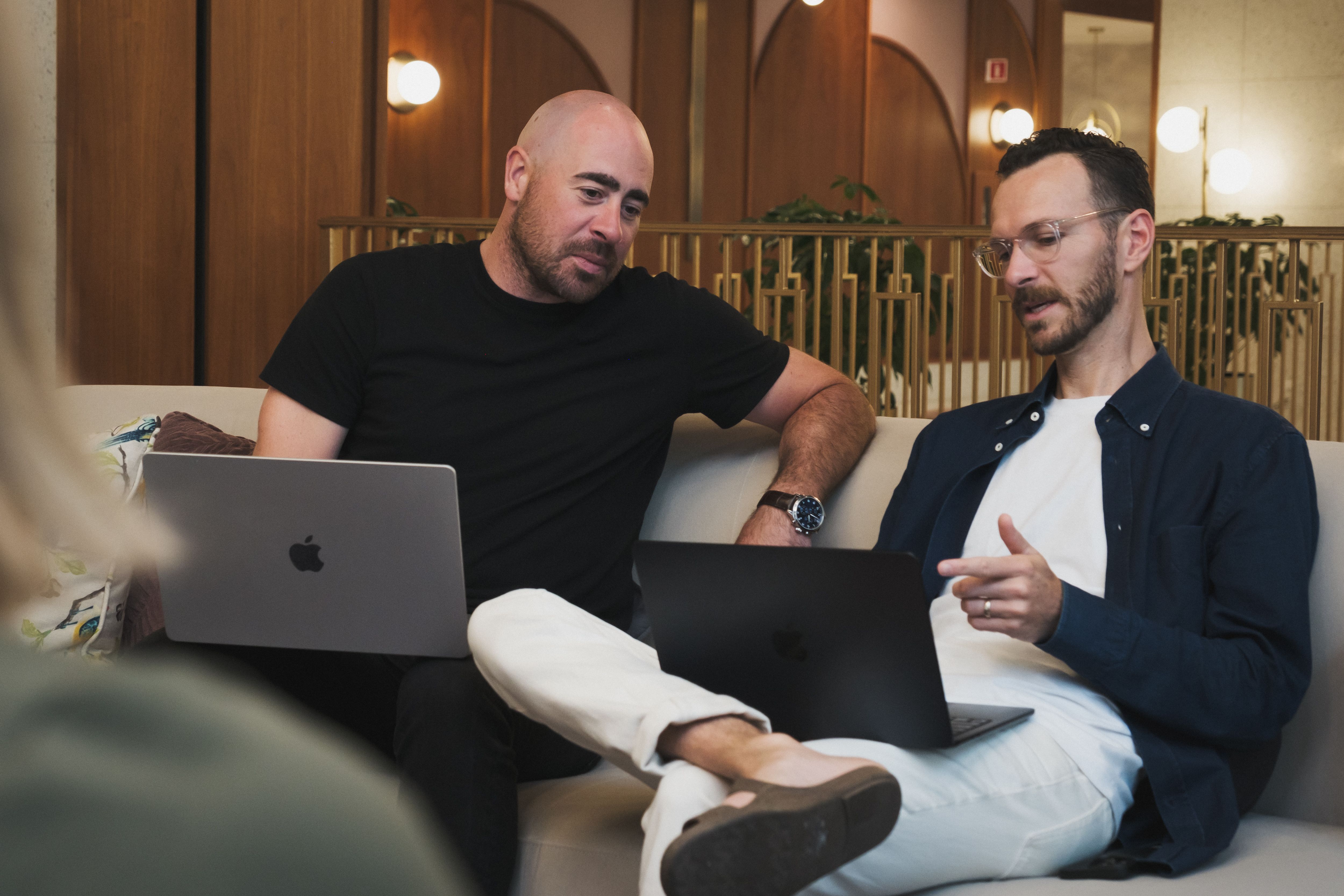 Two team members on their laptops on couches
