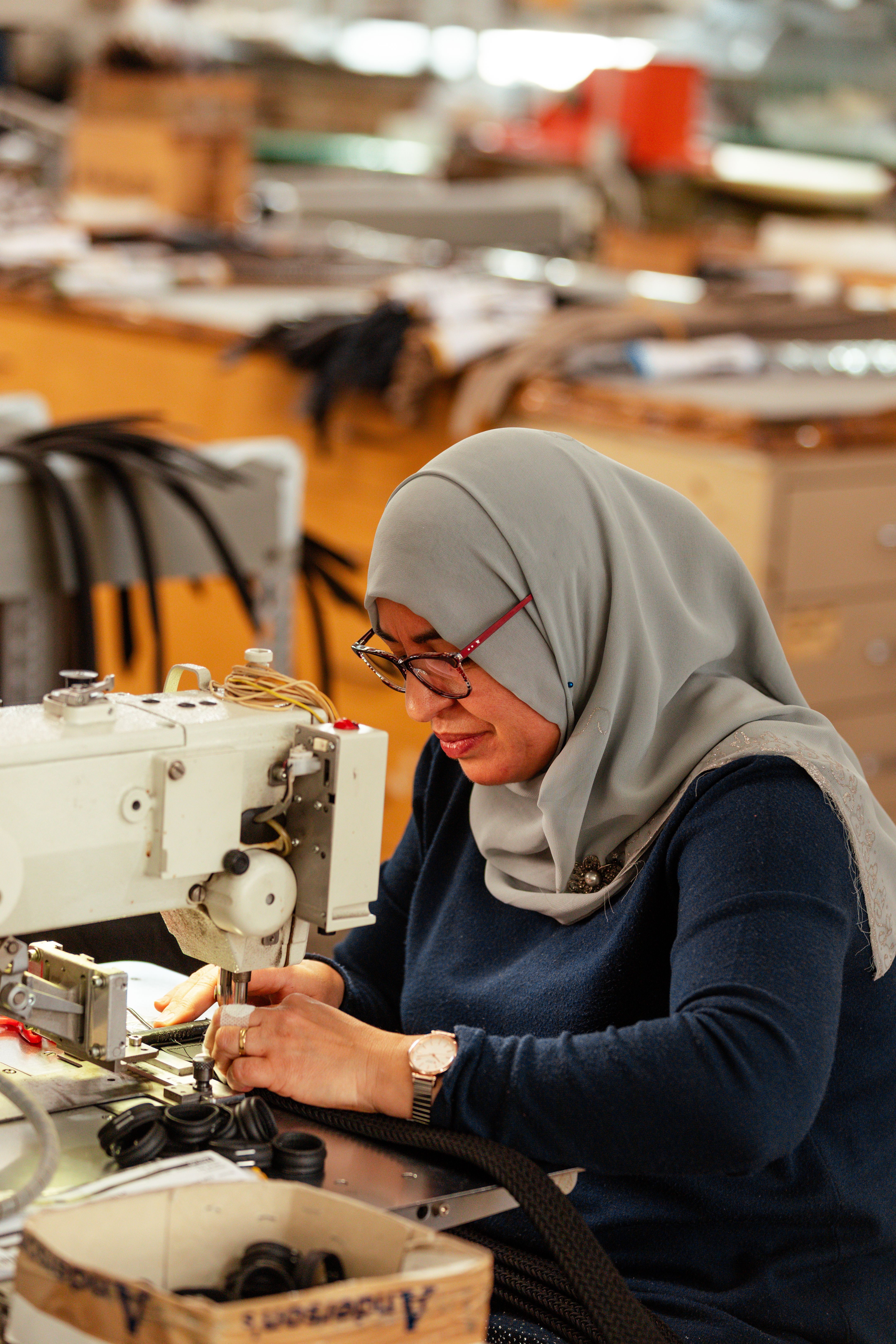 A seamstress working at a sewing machine in the Anderson's workshop