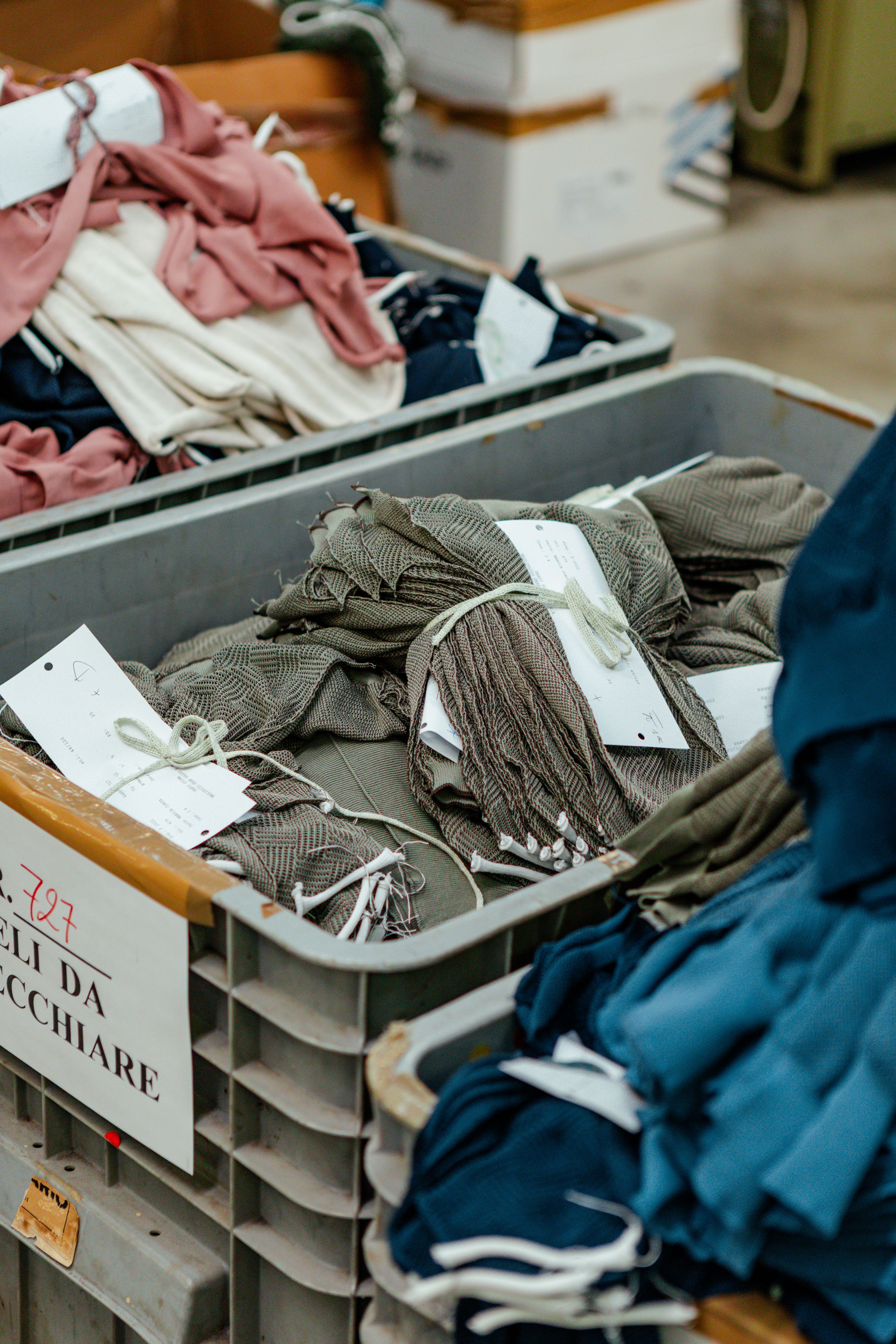 Factory trolleys stacked with folded garments and production tags