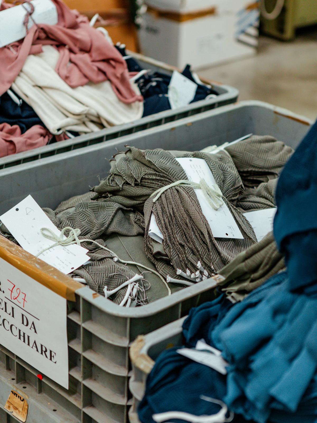 Factory trolleys stacked with folded garments and production tags