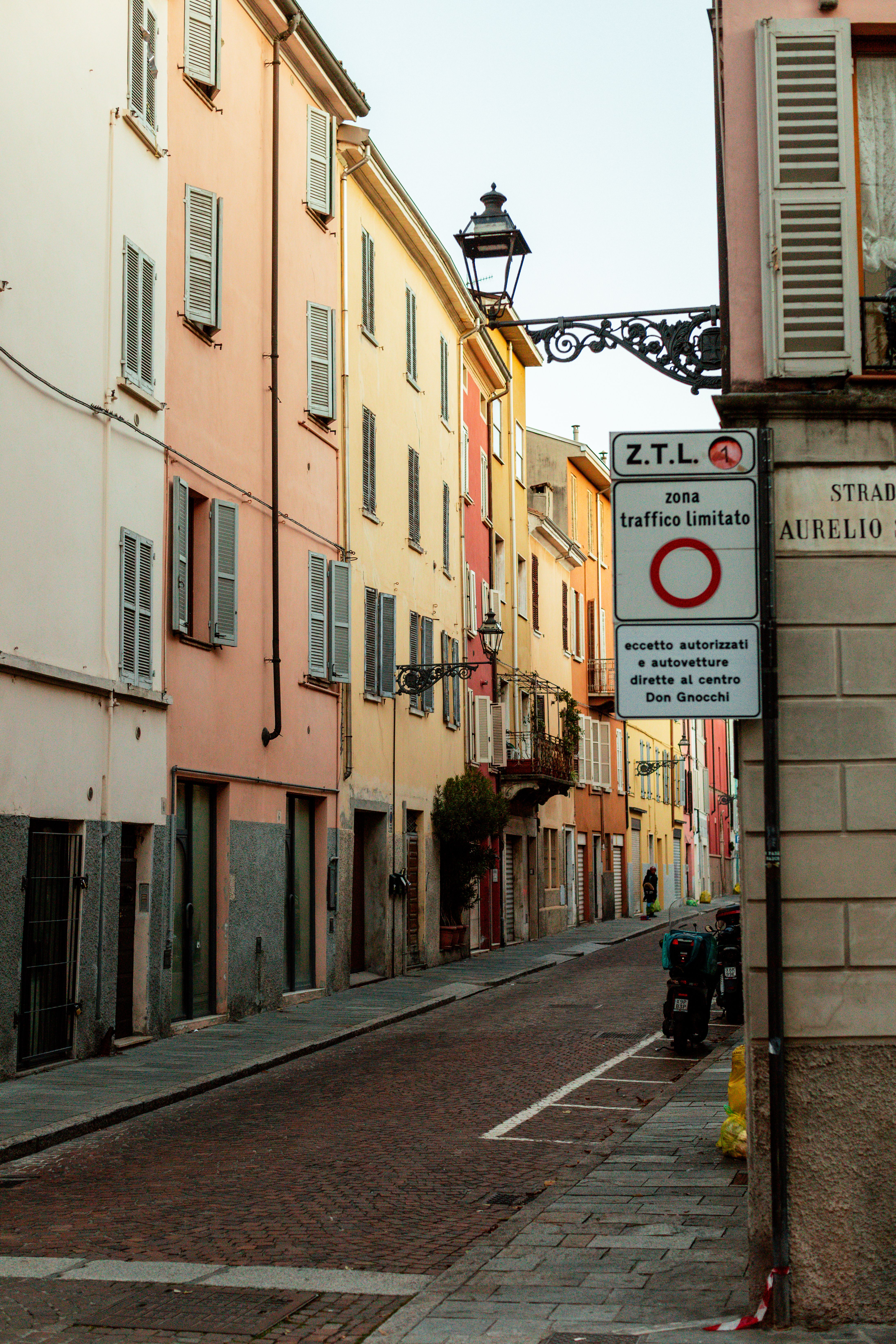 A narrow street in Parma lined with pastel-coloured buildings
