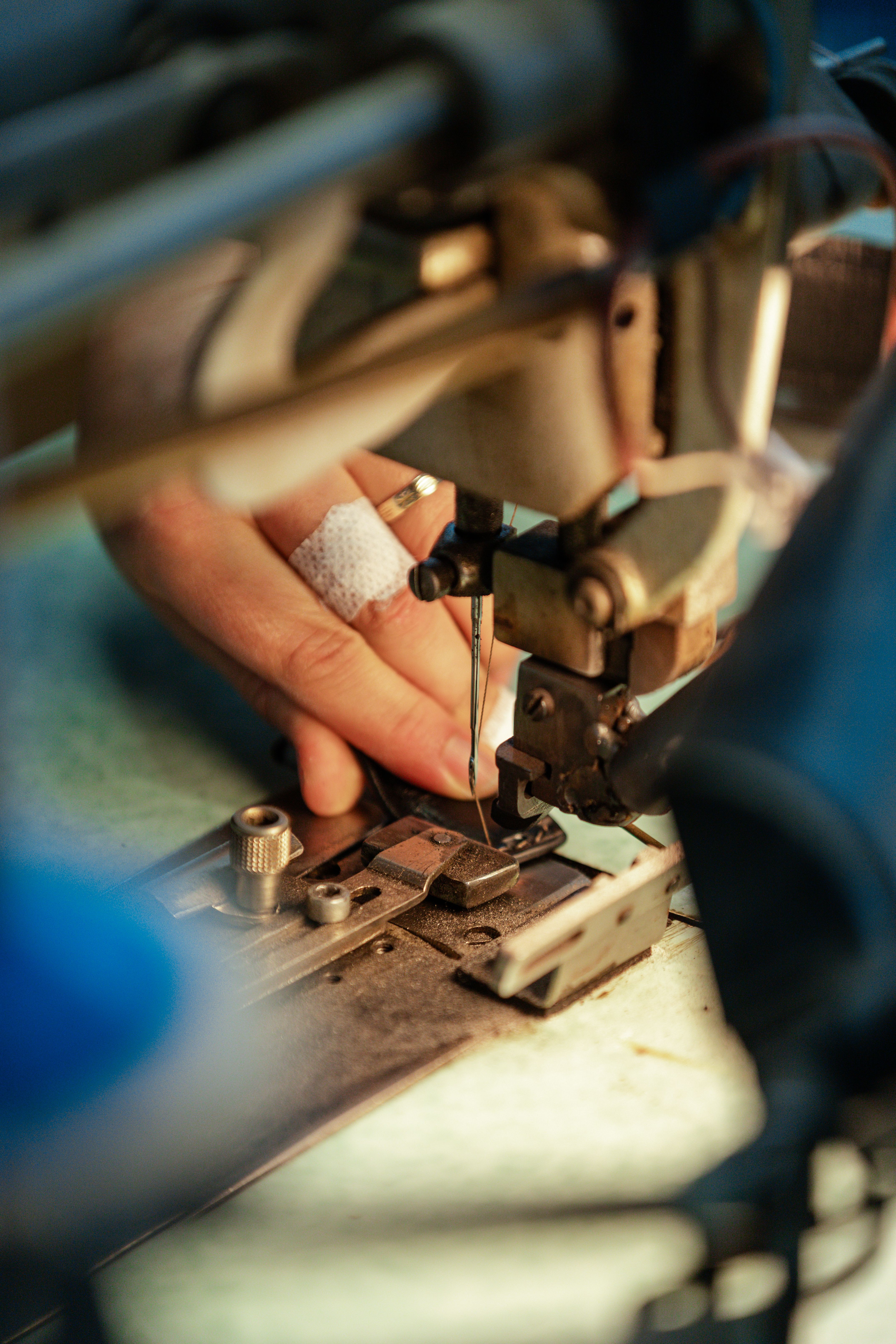 Close-up of hands assembling a leather belt at a workshop machine