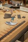 Leather strips and a half-moon leather knife on a workbench