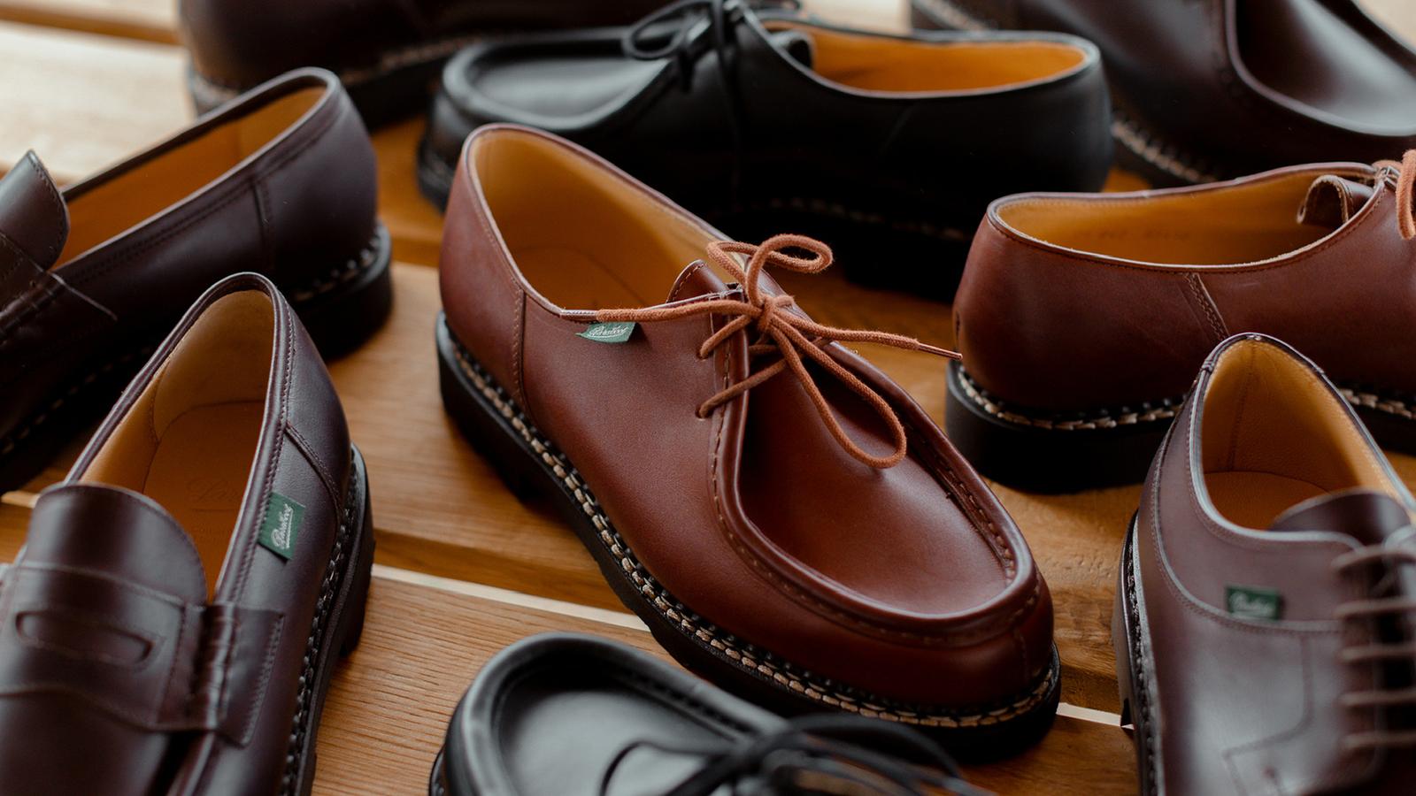Several pairs of brown leather derby shoes arranged on a wooden surface