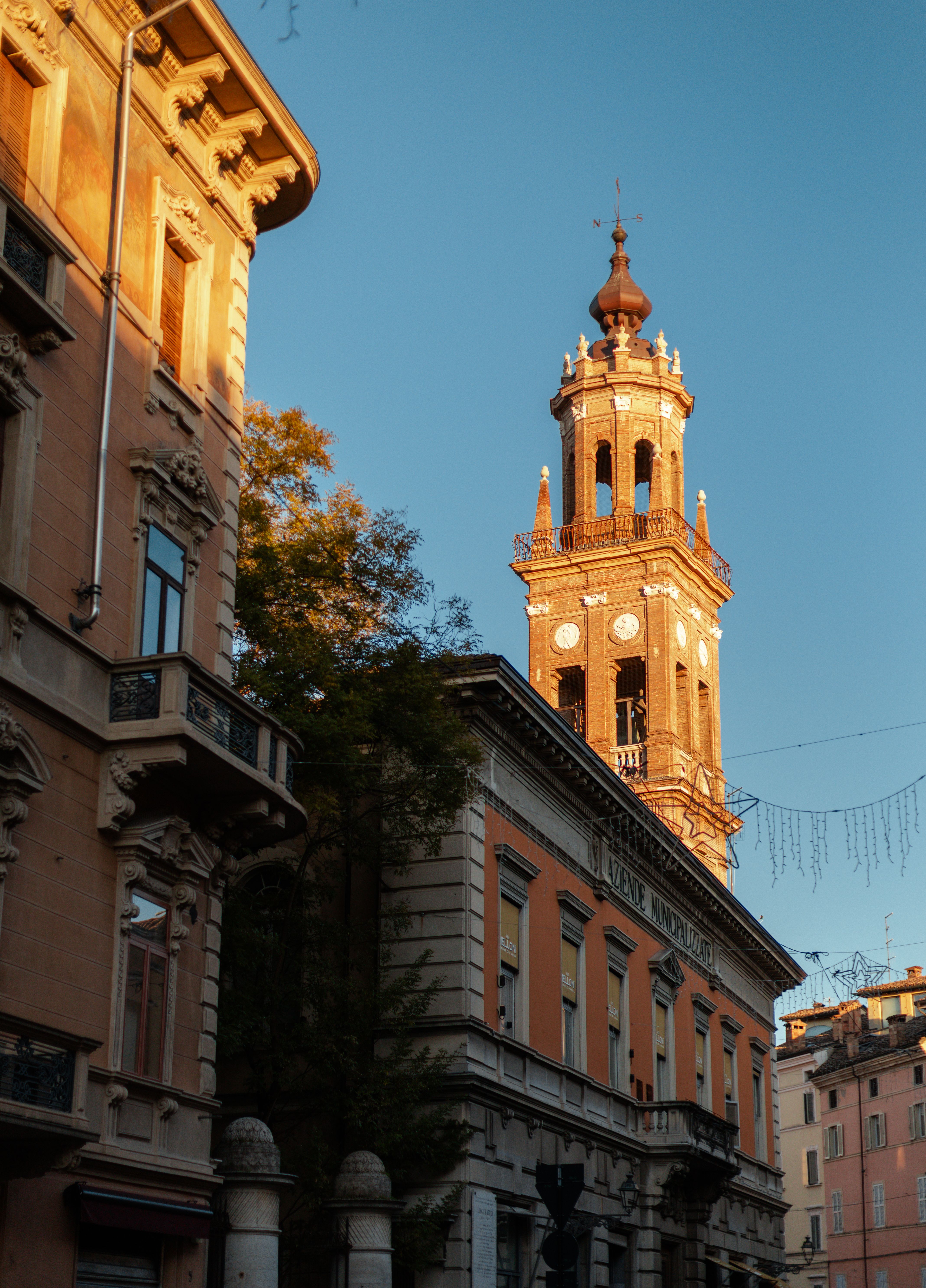 A church bell tower in Parma lit by late afternoon sun