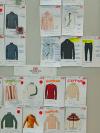 A wall board pinned with technical garment sketches and specification sheets