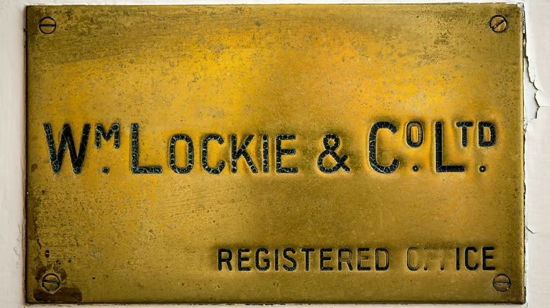 A weathered brass plaque engraved Wm Lockie & Co Ltd, Registered Office