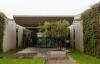 The entrance courtyard of a modern factory building with an olive tree