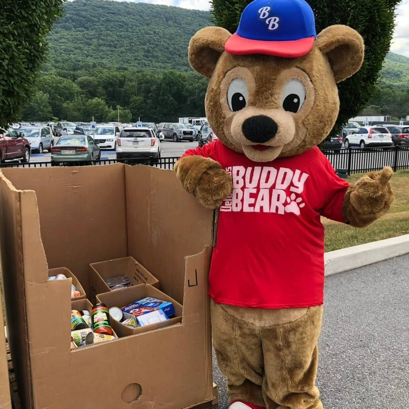Buddy Bear with non-perishable food donations at the park.