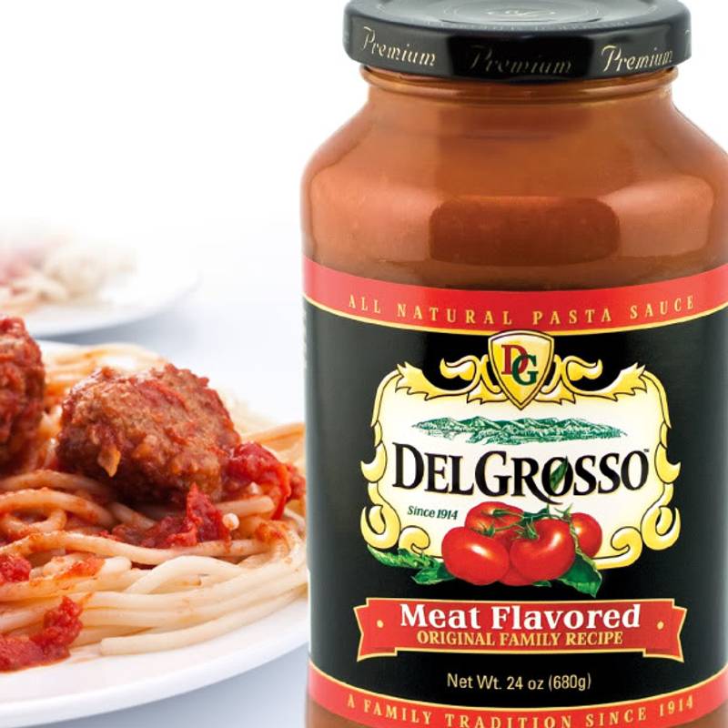 plate of spaghetti and meatballs on table with DelGrosso sauce jar beside