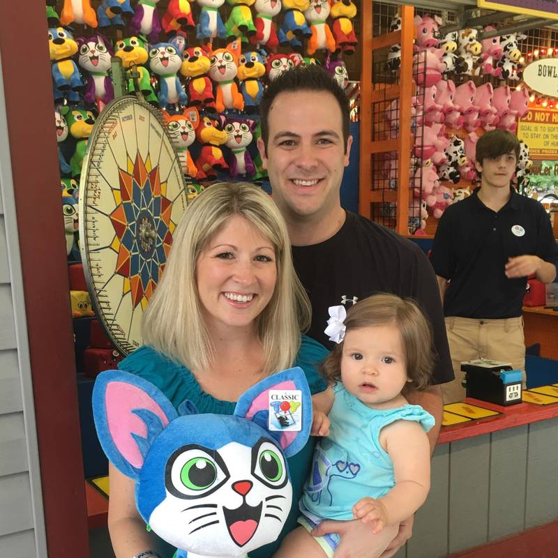 Mom, Dad, and baby in front of DelGrosso's Park Games.