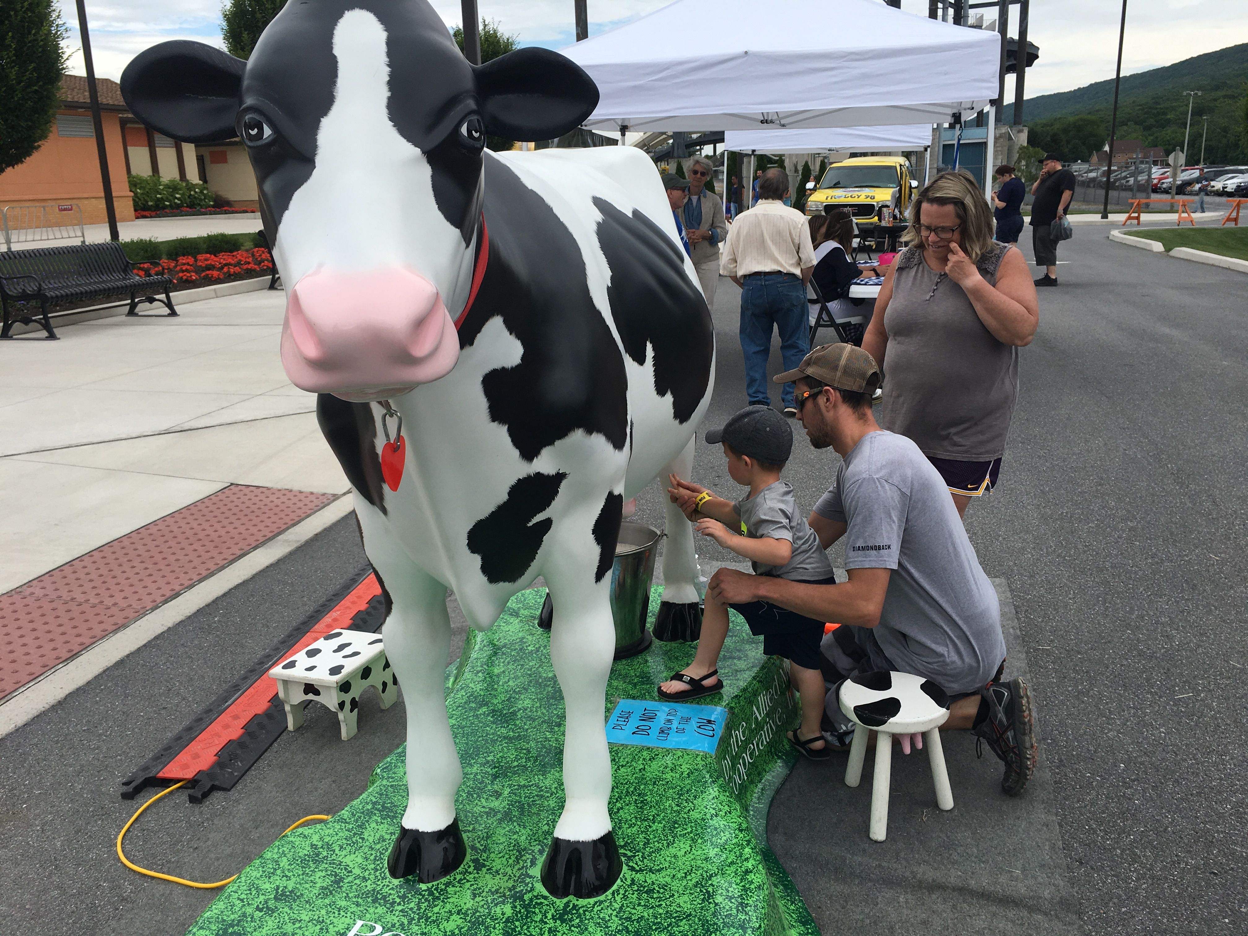 family "milking" cow statue