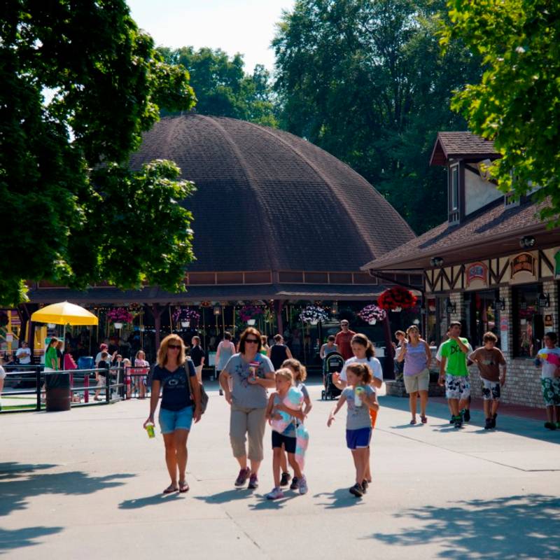 Guests with food and drink walking thru the midway of DelGrosso's Park.