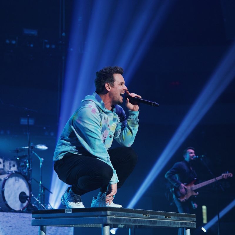 Image of singers Unspoken performing on stage in front of the microphone