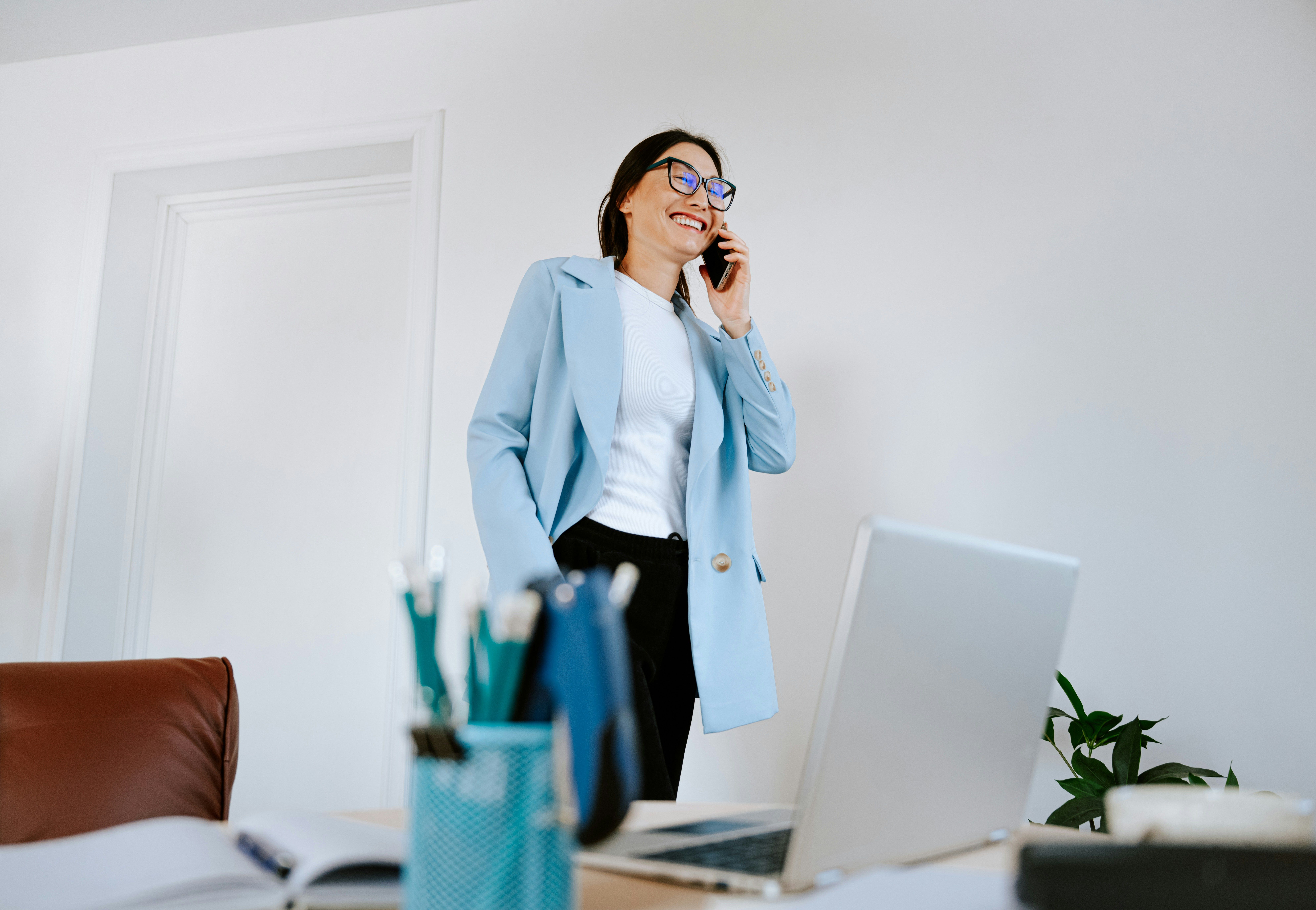 Business woman in a light blue blazer talking on her phone