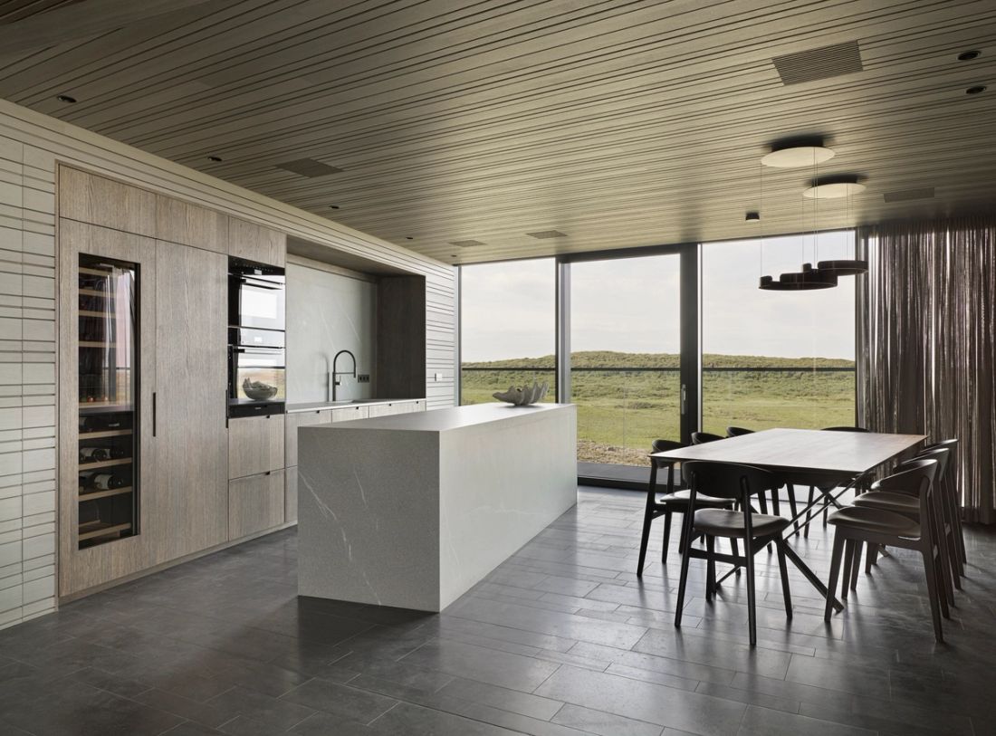 Eldhús og borðstofa undir timburlofti með lýsingu í loftlistum